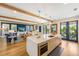 Open kitchen with island, stainless steel appliances, and light wood cabinets at 108 Tern Dr, Anna Maria, FL 34216