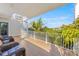 Relaxing balcony with spiral staircase, tropical views and wicker seating at 108 Tern Dr, Anna Maria, FL 34216