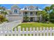 Two-story home with white picket fence and manicured lawn at 108 Tern Dr, Anna Maria, FL 34216