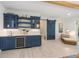 Basement bar with blue cabinetry, wine cooler, and a barn door at 108 Tern Dr, Anna Maria, FL 34216