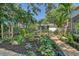 Tropical backyard with lush landscaping, brick pathways, and a patio at 1910 Morris St, Sarasota, FL 34239