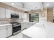 Bright kitchen featuring white cabinets, stainless steel appliances, and a large window at 4714 Elder Berry Dr, Sarasota, FL 34241
