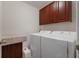 Convenient laundry room with washer, dryer, and overhead cabinets at 335 Gris Sky Ln, Bradenton, FL 34212