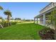 A large, well-maintained backyard with a covered patio and freshly planted trees at 7016 Foxboro Way, Nokomis, FL 34275