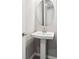 Bathroom with a round mirror and pedestal sink at 7016 Foxboro Way, Nokomis, FL 34275