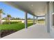 A covered patio overlooks a lush, green lawn and manicured landscaping at 7016 Foxboro Way, Nokomis, FL 34275