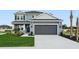 Charming two-story home with gray siding, manicured lawn, and a two-car garage at 7016 Foxboro Way, Nokomis, FL 34275