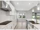 Modern kitchen featuring an island, stainless steel appliances, and large windows with backyard views at 7016 Foxboro Way, Nokomis, FL 34275
