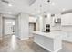 Open kitchen featuring stainless steel appliances, a spacious island, and white cabinets at 7016 Foxboro Way, Nokomis, FL 34275