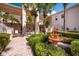 Two-story building exterior with lush landscaping, a courtyard fountain and walkway at 4244 Central Sarasota Pkwy # 725, Sarasota, FL 34238
