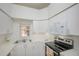 Well-equipped kitchen with white cabinets, stainless steel appliances, and tile flooring at 4244 Central Sarasota Pkwy # 725, Sarasota, FL 34238
