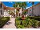 Two-story building exterior with lush landscaping, a courtyard fountain and walkway at 4244 Central Sarasota Pkwy # 725, Sarasota, FL 34238