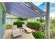 Covered patio with awning, lounge chairs, landscaped garden, and access to the home's interior at 8607 51St W Ave, Bradenton, FL 34210