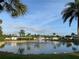 Tranquil lake in a 55+ community with lush landscaping and fountain at 191 Palm Air Dr, Osprey, FL 34229