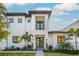 Stunning two-story home features a clean white facade, balcony, and lush landscaping at 2440 Floyd St, Sarasota, FL 34239