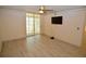Bright living room with wood-look floors, sliding glass doors and ceiling fan at 6101 34Th W St # 1E, Bradenton, FL 34210