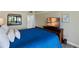 Comfortable bedroom with a large TV and blue bedding at 3805 E Bay Dr # 204, Holmes Beach, FL 34217