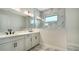 Bathroom with double vanity, quartz counters, decorative wall tiles, and modern lighting at 429 Alberata Way, Nokomis, FL 34275