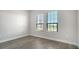 Cozy bedroom with wood floors, neutral walls, and windows overlooking the neighborhood at 429 Alberata Way, Nokomis, FL 34275