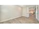 Minimalist bedroom with wood floors, white trim and walls, and an open door to the kitchen at 429 Alberata Way, Nokomis, FL 34275