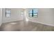 Bright bedroom with wood-look tile flooring, large windows, and neutral paint at 429 Alberata Way, Nokomis, FL 34275