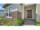 Welcoming front entrance with stylish stonework, a modern front door, and lush greenery at 429 Alberata Way, Nokomis, FL 34275