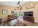 Living area with sliding glass doors to backyard and a large TV at 5201 Highbury Cir, Sarasota, FL 34238