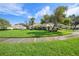 Side yard view showing lush green grass and mature trees at 5201 Highbury Cir, Sarasota, FL 34238