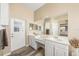 Bright bathroom with double sinks, a large mirror, and an exterior door at 5201 Highbury Cir, Sarasota, FL 34238