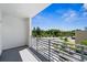 Balcony with metal railing and green space and parking lot views under blue sky at 1703 N Tamiami Trl # 302, Sarasota, FL 34234