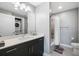 Bright bathroom featuring a quartz countertop vanity, full tub with tile surround, and convenient in-unit laundry at 1703 N Tamiami Trl # 302, Sarasota, FL 34234