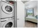 Convenient in-unit laundry closet featuring a stacked Samsung washer and dryer adjacent to the main bedroom at 1703 N Tamiami Trl # 302, Sarasota, FL 34234