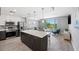 Open floor plan connecting a modern kitchen and a living room, filled with natural light at 1703 N Tamiami Trl # 302, Sarasota, FL 34234