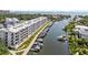 Waterfront condo building with boat docks and lush landscaping at 1703 N Tamiami Trl # 302, Sarasota, FL 34234