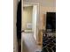 Narrow hallway featuring neutral walls, carpet flooring, a television, and a mirrored console table at 3375 8Th St, Sarasota, FL 34237