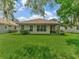Well-maintained backyard featuring a covered patio, lush lawn, and manicured landscaping that enhances outdoor living at 4145 Reflections Pkwy, Sarasota, FL 34233