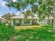 Well-maintained backyard with lush green lawn, mature trees, and outdoor seating area at 4145 Reflections Pkwy, Sarasota, FL 34233