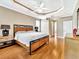 Spacious main bedroom with wood floors, tray ceiling and ceiling fan at 4145 Reflections Pkwy, Sarasota, FL 34233