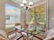 Bright dining area with a glass table and four chairs overlooking the landscaped yard at 4145 Reflections Pkwy, Sarasota, FL 34233