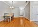 Open dining room with hardwood floors, a chandelier, and access to the front door at 4145 Reflections Pkwy, Sarasota, FL 34233