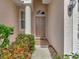 Inviting entryway featuring a classic front door with a decorative window and brick tile landing at 4145 Reflections Pkwy, Sarasota, FL 34233