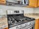 Modern kitchen featuring stainless steel appliances, a gas range, and granite countertops at 4145 Reflections Pkwy, Sarasota, FL 34233