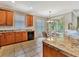 Bright kitchen with tile flooring, wooden cabinets, and a view of the dining area and backyard at 4145 Reflections Pkwy, Sarasota, FL 34233