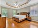 Spacious main bedroom with tray ceiling, fan, and natural light from two windows at 4145 Reflections Pkwy, Sarasota, FL 34233
