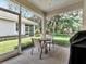 Cozy screened-in patio with two chairs and a table overlooking the lush backyard at 4145 Reflections Pkwy, Sarasota, FL 34233