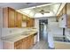 View of kitchen with wood cabinets, white appliances, and a double sink at 505 30Th W Ave # E304, Bradenton, FL 34205