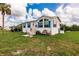 Single-story manufactured home with blue accents and landscaping at 14564 Frizzell Rd, Port Charlotte, FL 33953