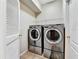 Laundry room with washer and dryer, overhead shelving, and tiled floor at 4145 Reflections Pkwy, Sarasota, FL 34233