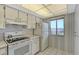 Efficient kitchen with white cabinets, electric range and refrigerator at 8911 Midnight Pass Rd # 410, Sarasota, FL 34242