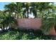 Sunrise Cove Yacht and Racquet Club entrance, showcasing a tropical landscape at 8911 Midnight Pass Rd # 410, Sarasota, FL 34242